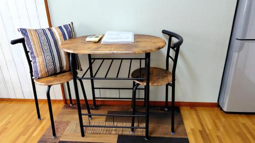 a small table with two chairs next to a refrigerator at Kokusaigakusya Ozukikaikan - Vacation STAY 17326 in Hadano