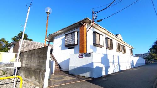 a small white house on a street at Kokusaigakusya Ozukikaikan - Vacation STAY 17510 in Hadano