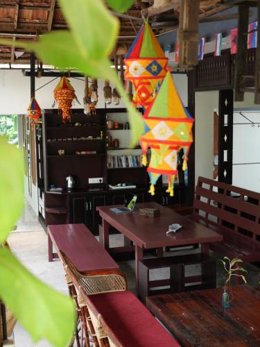 a restaurant with benches and kites hanging from the ceiling at Munroeisland Backwaters Homestay in Munroe Island