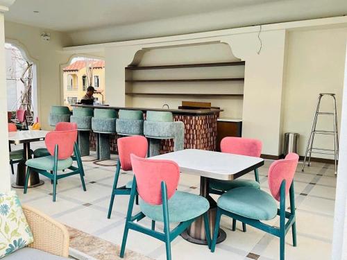 a restaurant with pink and blue chairs and tables at Biệt Thự Hồ Tràm 3636 in Ấp Thanh Bình