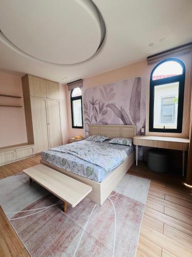 a bedroom with a large bed and two windows at Biệt Thự Hồ Tràm 3636 in Ấp Thanh Bình