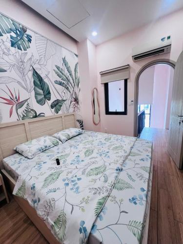 a bedroom with a bed with a floral wall at Biệt Thự Hồ Tràm 3636 in Ấp Thanh Bình