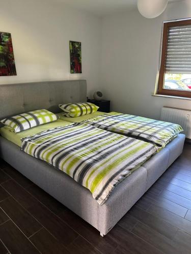 a bedroom with a bed with a yellow and black comforter at Ferienwohnung Obersulm in Obersulm