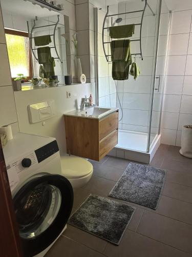 a bathroom with a toilet and a sink and a shower at Ferienwohnung Obersulm in Obersulm