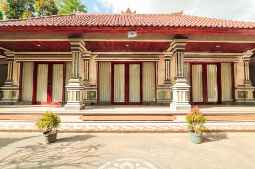 a building with two potted plants in front of it at Vaneka Garden House in Ubud
