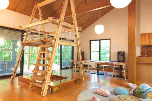 a loft bed in a room with a dining room at KIZUKI 子供の記憶にいつまでも思い出が残る場所 虫も天気も気にせず屋内bbq 遊具 大浴場 in Nasu