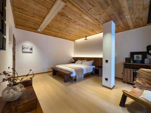 a bedroom with a bed and a wooden ceiling at M Country Road 山行野奢影院温泉民宿 in Dujiangyan