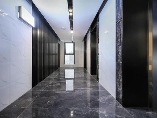 a hallway with black and white walls and marble floors at 成都锦禧悦庭酒店宽窄巷子店 in Chengdu
