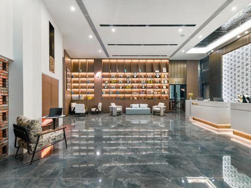 a lobby with a waiting area with couches and chairs at 成都锦禧悦庭酒店宽窄巷子店 in Chengdu
