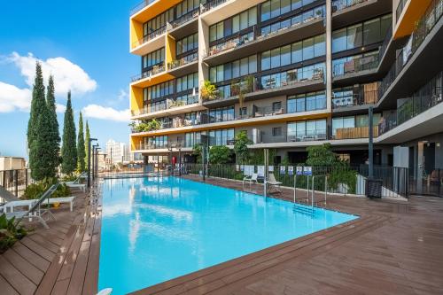 an empty swimming pool in front of a building at Boutique Duplex 3BR Florentin in Mashabbe Sade