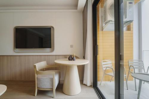 a room with a table and chairs and a tv at Wyndham Gardens Elegant Studio Forrest View 2228 in Nai Thon Beach