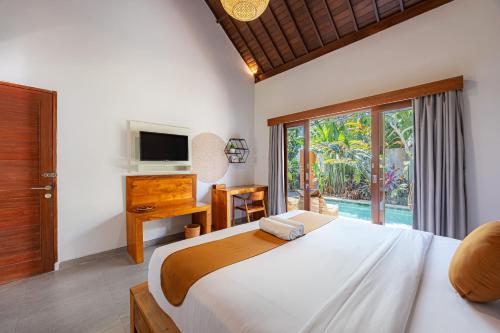 a bedroom with a large bed and a television at Cove Belle Asana in Canggu
