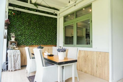 a patio with a table and chairs and a green wall at Riverdale Villa Bandung in Bongkor 1