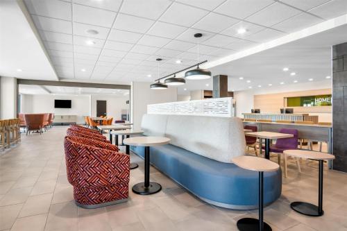 a lobby of a restaurant with tables and chairs at Home2 Suites by Hilton Irving/DFW Airport North in Irving