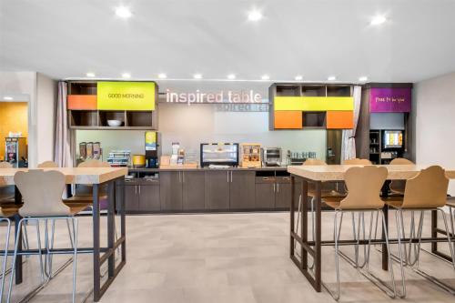 a kitchen with two tables and chairs in a store at Home2 Suites by Hilton Irving/DFW Airport North in Irving