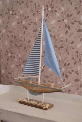 a wooden toy sailboat sitting on a shelf at Barcolana Lodge Hostel in Trieste