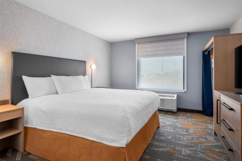 a hotel room with a large bed and a window at Home2 Suites by Hilton Irving/DFW Airport North in Irving
