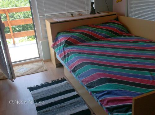BliznatsiにあるPhilippa & Souzana Holiday Homesのカラフルな毛布が備わるドミトリールームのベッド1台分です。