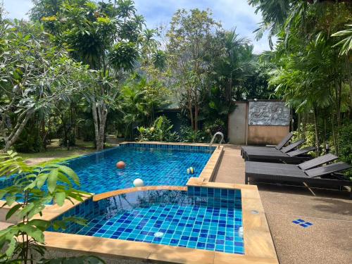 a swimming pool with blue tiles in a garden at Moubillow Resort in Ao Nang Beach