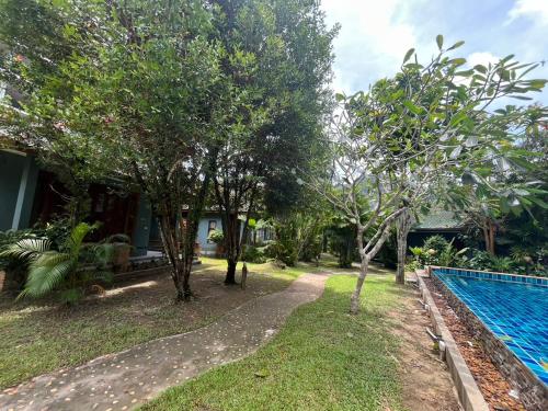 a villa with a swimming pool and trees at Moubillow Resort in Ao Nang Beach