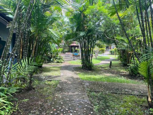 a path through a garden with palm trees at Moubillow Resort in Ao Nang Beach