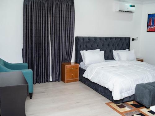 a bedroom with a bed and a blue chair at MetroNest Apartments in Lekki