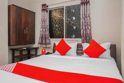ein Schlafzimmer mit einem großen Bett mit roten Kissen in der Unterkunft Hotel O Indraprastha Executive in Phūrsungi