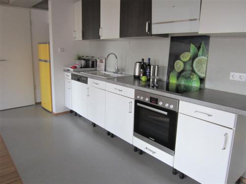 a kitchen with white cabinets and a black oven at K9 Wohnungen in Münster