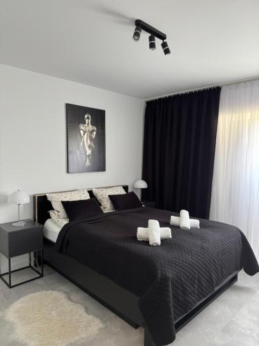 a bedroom with a large black bed with two pillows at Apartamenty Cegielnia 1 Lux-Haus in Gorzów Wielkopolski
