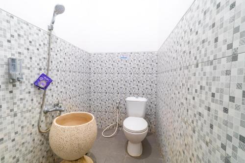 a bathroom with a toilet and a shower at Griya Kulon Yogya in Jetis