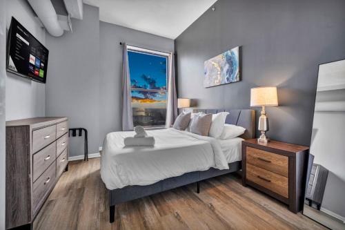 a bedroom with a bed and a tv and a window at 1BR Loft Sauna & Walk to Theater & Campus in Cleveland