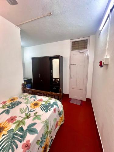 a bedroom with a bed and a flat screen tv at Varma Brick House in Manipala
