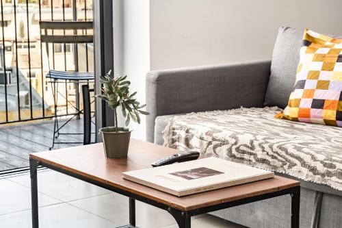 a living room with a coffee table with a book at Boutique Duplex 3BR Florentin in Mashabbe Sade