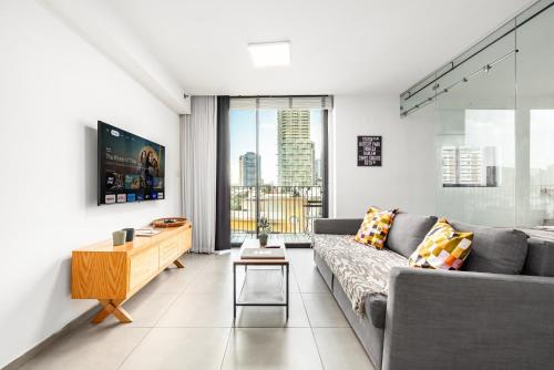 a living room with a couch and a table at Boutique Duplex 3BR Florentin in Mashabbe Sade