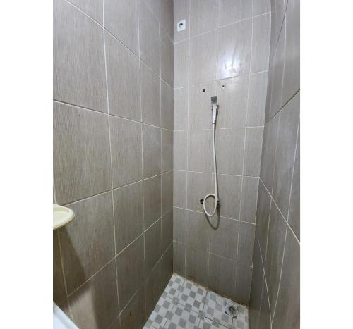 a bathroom with a shower with a tiled floor at OYO 94776 Griya Cempaka in Tarakan