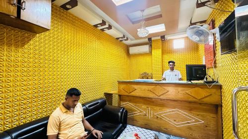 two men sitting at a bar in a restaurant at Hotel zam Zam Residential in Dhaka