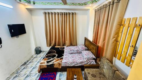 a small room with a bed and a tv at Hotel zam Zam Residential in Dhaka