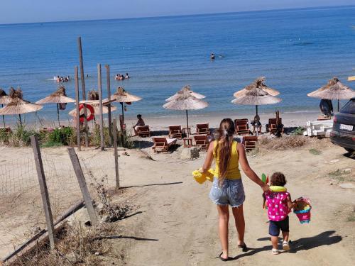 a woman and a child walking on the beach at Hotel Lalez Durres in Durrës