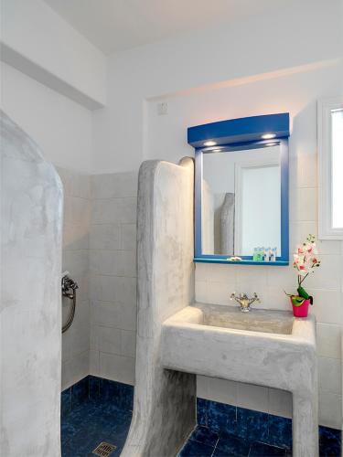 a bathroom with a sink and a mirror at Aloni Hotel & Suites in Piso Livadi