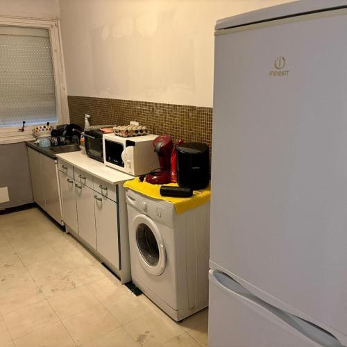 a kitchen with a washing machine and a refrigerator at charmant T2 avec balcon in Ris-Orangis