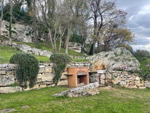 a stone wall with a bench in a yard at Il Nido del Falco nelle Antiche Mura in Saturnia