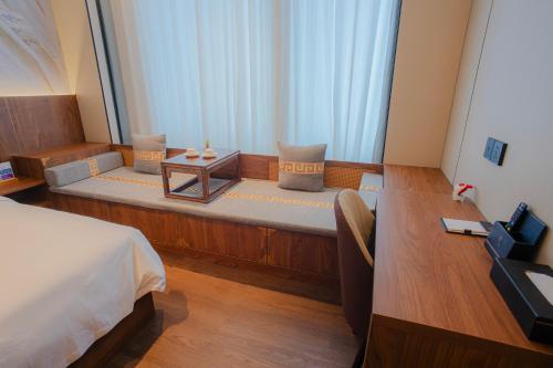 a small room with a bed and a table at Huafeng Hotel 