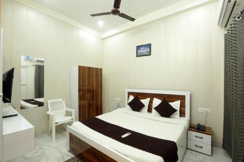 a bedroom with a bed and a chair in it at Shri Raghav Palace I Hotel In Ayodhya in Ayodhya