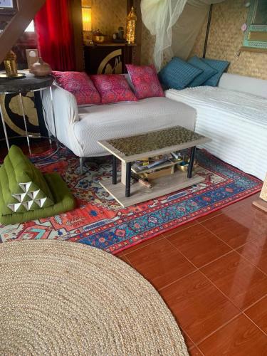 a living room with a couch and a table on a rug at Serenity Beachfront Bungalow Ko Samui in Amphoe Koh Samui