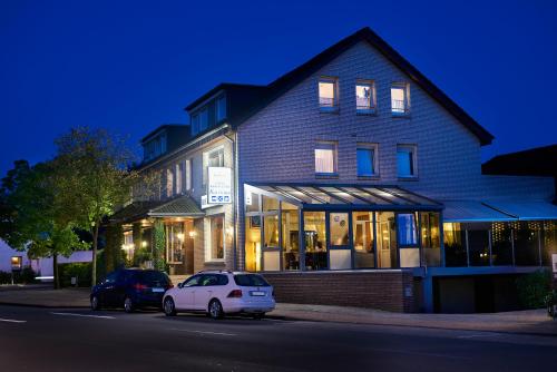 a building with a white car parked in front of it at Landgasthaus Hotel H. Kortlüke in Belm