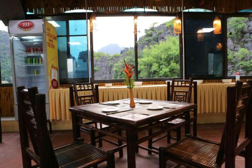 a table with a vase on it in a restaurant at Tam Coc Lion Kings Hotel & Resort Ninh Binh in Ninh Binh