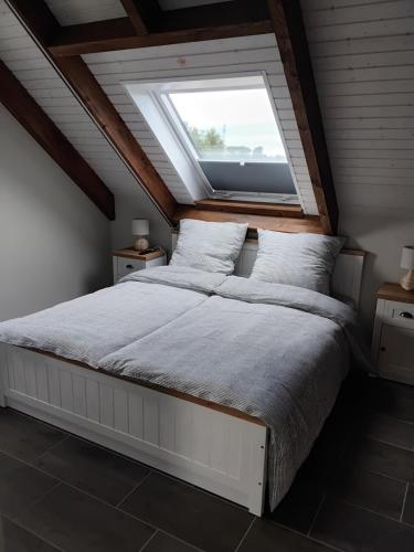 a bedroom with a large bed with a skylight at Neue Welt Ferienwohnung 1 in Osteel