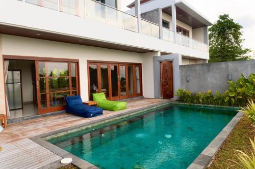 a swimming pool in front of a house at Ada Villa in Panji