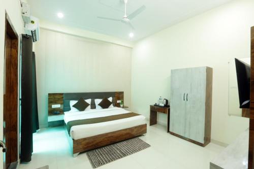 a bedroom with a bed and a television in it at Shri Raghav Palace I Hotel In Ayodhya in Ayodhya