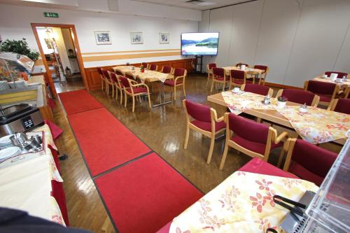a dining room with tables and chairs and a screen at CProoms24 in Miesenbach